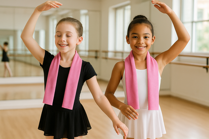 two young girls in dance class, wearing pink cooling towel around neck